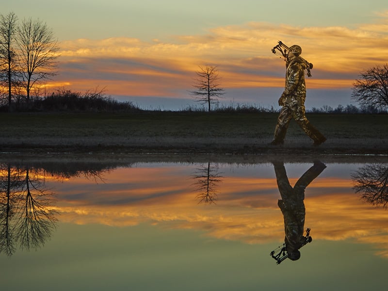 man bowhunting in rocky men's outdoor boots by lake